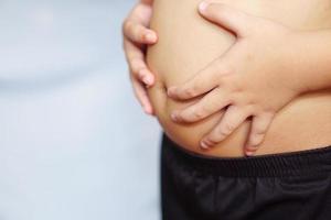 Fat boy touched his belly. Health, treatment and exercise concept. photo