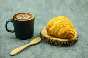 taza de café moca caliente y croissant recién hecho. concepto de alimentación saludable y comida dulce.