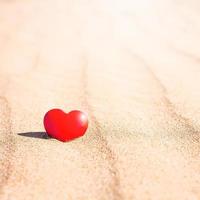 símbolo romántico de corazón rojo en la playa de arena foto