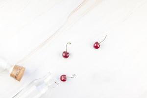 Glass bottles and ripe cherries photo