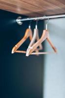 Empty Wooden hangers on rail in closet photo