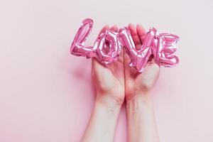 Love concept. Inflatable pink balloon in hands photo