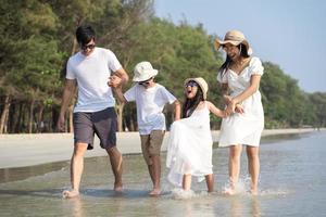 Asian Family walking at beach with kids happy vacation concept photo