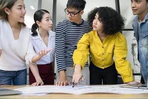 grupo de jóvenes y serios empresarios asiáticos creativos que se reúnen en una oficina moderna para planificar y compartir ideas foto