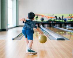 lindo niño con pelota en el club de bolos foto