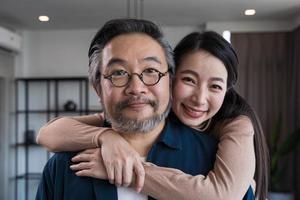 pareja asiática de mediana edad sonriendo para la cámara. retrato de pareja familiar foto