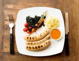 grilled sausages on white plate photo