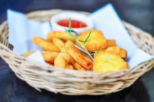 fried onion ring with chicken nuggets in a beautiful wodden basket with tomato ketchup photo