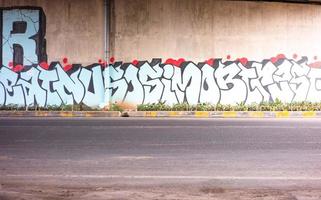 gresik, jawa timur, indonesia, 2022 - pared al borde de la carretera pintada con escritura interesante foto