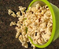 high view of ripe popcorn served in green bowl.close up .In addition to helping you lose weight, eating popcorn also has other health benefits. photo