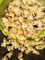 high view of ripe popcorn served in green bowl.close up .In addition to helping you lose weight, eating popcorn also has other health benefits. photo