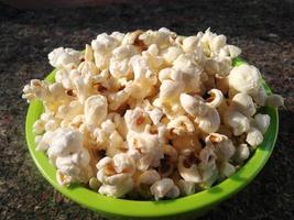 high view of ripe popcorn served in green bowl.close up .In addition to helping you lose weight, eating popcorn also has other health benefits. photo