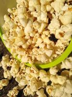 high view of ripe popcorn served in green bowl.close up .In addition to helping you lose weight, eating popcorn also has other health benefits. photo