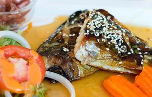 closeup grilled fish fillets on white plate photo