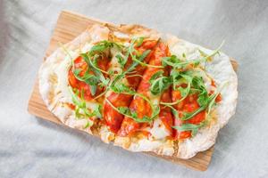 crispy pan pizza on wooden plate photo