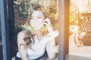 Lady happily using mobile phone in coffee shop photo