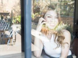 Lady happily using mobile phone in coffee shop photo