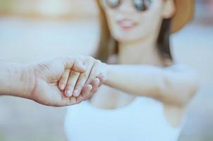 enfoque suave de la mano sosteniendo otra mano de niña borrosa foto