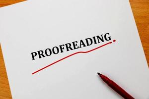 proofreading word on white sheet with red pen photo