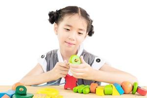 Lovely asian girl is play colorful wood block toy photo
