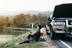 Man try to fix a car engine problem on a local road Chiang mai Thailand - people with car problem transportation concept photo