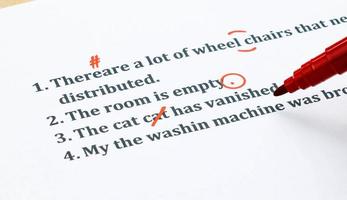 english sentences and correcting symbols on white sheet photo