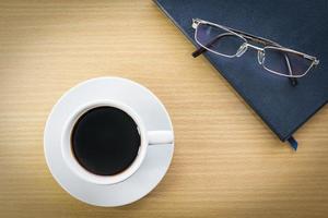 Coffee cup on wood deck and glasses photo