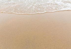 Wave of the sea on the sandy beach photo