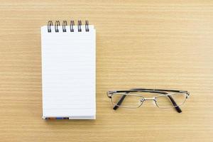 Eyeglasses and Notepad with blank page photo