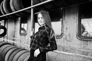 Young hipster girl in checkered shirt at tire fitting zone. photo