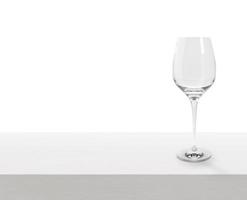 Empty wine glass on white wooden table with copy space photo