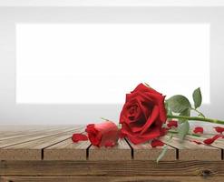 Red roses and rose petals on Wooden table top photo