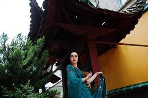 Portrait of beautiful indian brumette girl or hindu woman model against japanese traditional house. photo