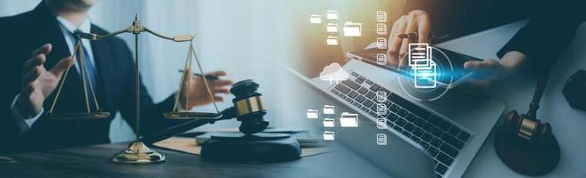 Justice and law concept.Male judge in a courtroom with the gavel, working with, computer and docking keyboard, eyeglasses, on table in morning light photo