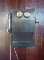 Antique old telephone hang on wooden wall photo