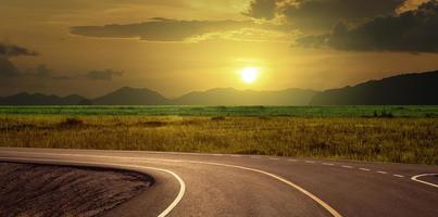 asphalt curve road at countryside at sunset photo