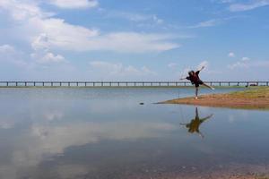 mujer saltando sobre el lago mientras viaja a lopburi tailandia en vacaciones de verano foto