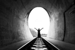 silueta de una persona adulta parada en el túnel del ferrocarril foto