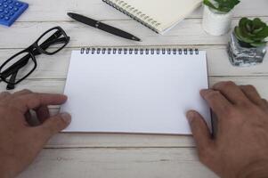 Hand holding blank white notepad with space customizable for text or ideas. Copy space for ideas photo