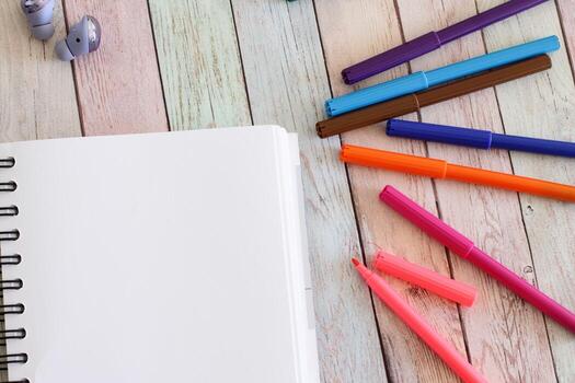 Notebook blank page and colorful felt-tip pens photo