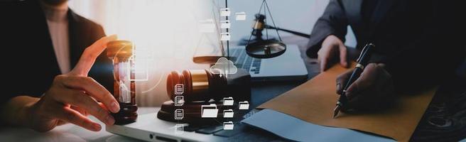 Justice and law concept.Male judge in a courtroom with the gavel, working with, computer and docking keyboard, eyeglasses, on table in morning light photo