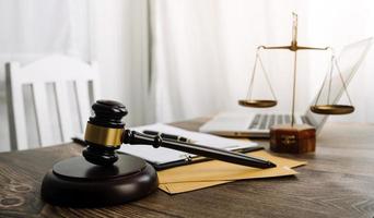 Business and lawyers discussing contract papers with brass scale on desk in office. Law, legal services, advice, justice and law concept picture with film grain effect photo