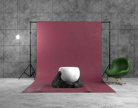 3D rendering interior of a photo studio. Red backdrop on a tripod in a concrete room. Abstract black and white sculpture in the form of a ball and stone, product platform, green armchair lit by lamp.