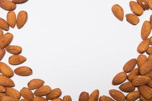 Whole almond nuts on the white background. Healthy vegetarian snack. Close-up photo. Copy-space for your text. High quality photo