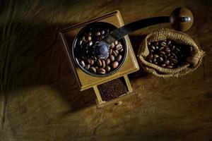 Vintage coffee grinder.Old retro hand-operated wooden and metal coffee grinder.Manual coffee grinder for grinding coffee beans. on the old wooden background.soft focus. photo