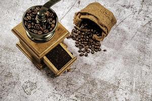 Vintage coffee grinder.Old retro hand-operated wooden and metal coffee grinder.Manual coffee grinder for grinding coffee beans. on the on the old stone floor. photo