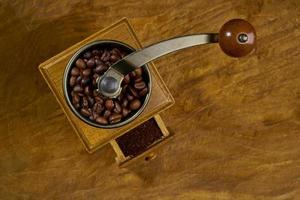 Vintage coffee grinder.Old retro hand-operated wooden and metal coffee grinder.Manual coffee grinder for grinding coffee beans. on the old wooden background.soft focus. photo