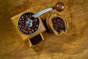 Vintage coffee grinder.Old retro hand-operated wooden and metal coffee grinder.Manual coffee grinder for grinding coffee beans. on the old wooden background.soft focus. photo