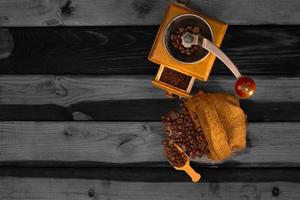 Vintage coffee grinder.Old retro hand-operated wooden and metal coffee grinder.Manual coffee grinder for grinding coffee beans. on the old wooden background. photo