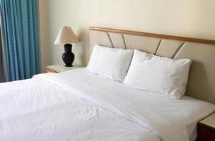 bedroom interior with pillow and table lamp photo